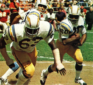 While he's usually remembered as a Kansas City Chief, Mike Garrett spent half his career with the San Diego Chargers. Here he takes a hand-off from Quarterback John Hadl and gets outside. Out in front blocking is long-time Charger Guard Doug Wilkerson. Wilkerson spent 14 years in San Diego and made 3 Pro Bowls. 
 One of Garrett's best seasons came as a Charger. In 1972 he rushed for 1031 yards and ran for 6 touchdowns.  