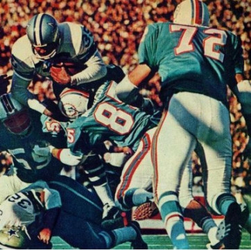 Cowboys runner Calvin Hill (#35) goes high over teammate Walt Garrison (#32) as Dolphins linebacker Nick Buoniconti (#85) and Doug Swift (#59) hit low. Bob Heinz (#72) moves in to help.   