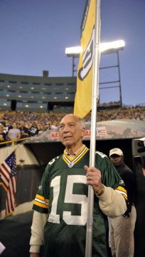 An aging Bart Starr holds the holds the Green Bay Packer flag.