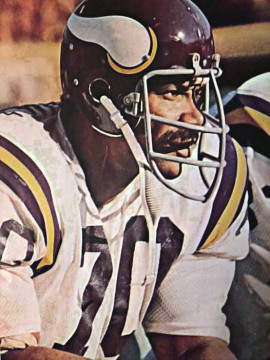 Defensive End out of Ohio State. Played 20 seasons in the NFL. Cleveland Browns in 1960 and the Minnesota Vikings in 1961 to 1979. Held NFL record for many years until broken by Brett Favre with 282 consecutive games played starting 270 of those with the Vikings. Ranks 2nd in Vikings history with 127 sacks. Played in 2 Pro Bowls (1968 and 1969). Led or tied for team lead in sacks in each of the Vikings first
6 seasons (1961-66). Holds NFL and Vikings record with 29 career fumble recoveries. Ranks 8th in Vikings history with 988 career tackles (only Alan Page has more). Along with fellow Vikings defenders Carl Eller, Gary Larsen and Alan Page formed the famous Purple People Eaters - one of the top defensive units of their era. Started in 4 Super Bowls (IV, VIII, IX, XI). Was originally a 4th-round draft pick by Cleveland but played in the Canadian Football League for year before joining the NFL in 1960. Member of 50 Greatest Vikings team named in 2010. Inducted into the Vikings Ring of Honor in November of 1999.