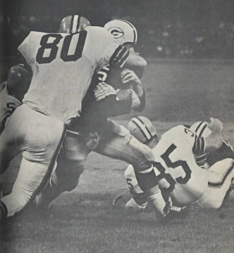 Cleveland defenders led by Pro Bowler Bill Glass swarm over Packers Hall of Famer Paul Hornung. Also pictured is longtime Browns linebacker Galen Fiss (#35).