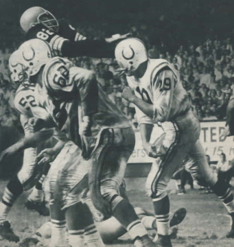 Early 1960s NFL action between Cleveland and Baltimore - Hall of Famer Johnny Unitas gets a pass of center Dick Szymanski (#52) and guard Palmer Pyle (#62) keep Browns defender Jim Houston (#82) at bay. 