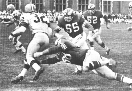 The Eagles defense closes in on Cleveland's great fullback Jim Brown (#32). As lineman Bobby Richards (#68) goes low All-Pro Maxie Baughan (#55) and Dave Lloyd (#52) come up to assist in the stop. Browns tight end Johnny Brewer (#83) is in the background.
