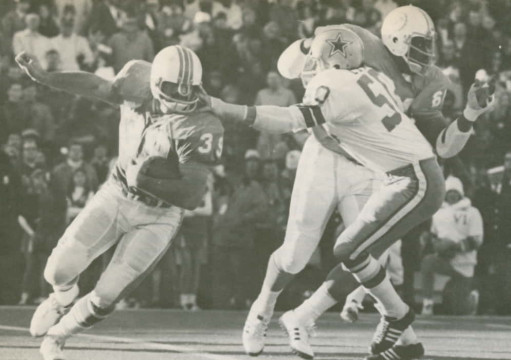 Dolphins fullback Larry Csonka (#39) works to get away from Cowboys linebacker DD Lewis (#50)