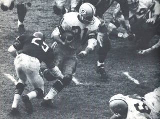 The Packers Jimmy Taylor runs through the Chicago Bears Defense