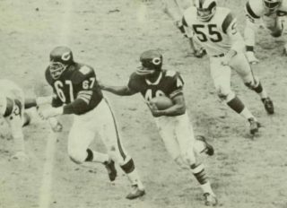 Gale Sayers behind the blocking of George Seals with Maxie Baughan in pursuit