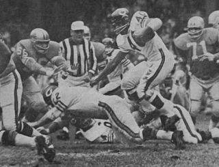 Bears runner Gale Sayers is surrounded by Detroit Lions Joe Schmidt and Alex Karras in 1965