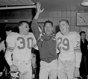 In the Giants locker room, Bill Svoboda, Emlen Tunnell & Alex Webster celebrate their 1956 NFL Championship win over the Bears with a photo.