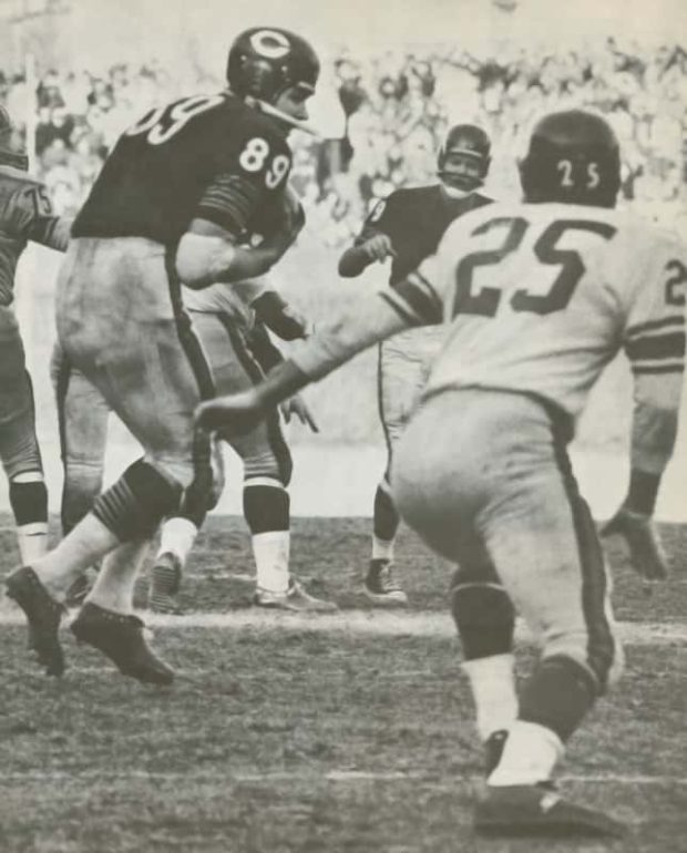 A black and white image of Mike Ditka catching a pass from Billy Wade during the 1963 NFL Title game at Wrigley Field.