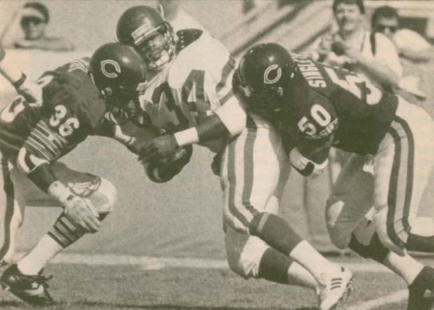 The Bears Mike Singletary and Marcus Paul stop the Vikings Herschel Walker.