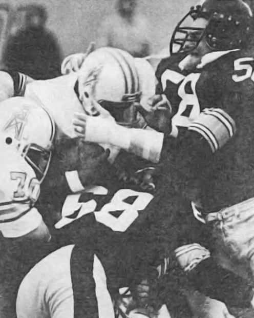 A black and white image captures Earl Campbell being tackled by LC Greenwood and Jack Lambert during an 1979 AFC Title game.