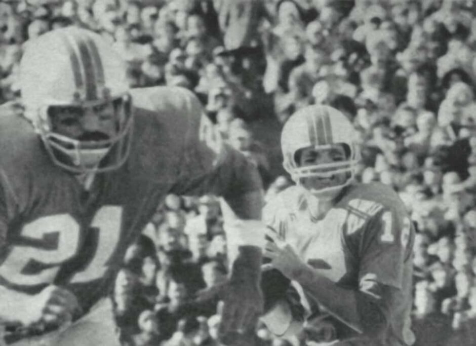 A black and white photo depicting Bob Griese throwing a pass as Jim Kiick runs, highlighting the Dolphins' historic 17-0 season.