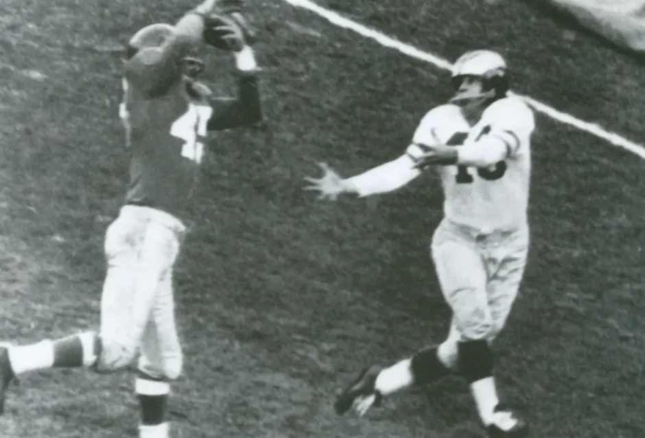 Black and white photo capturing Emlen Tunnell disrupting a pass to Ted Weggert in a 1955 NFL game.