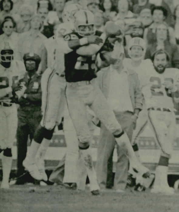 Black and white photo of Fred Biletnikoff catching a football during the 1976 AFC Championship game against the Patriots.