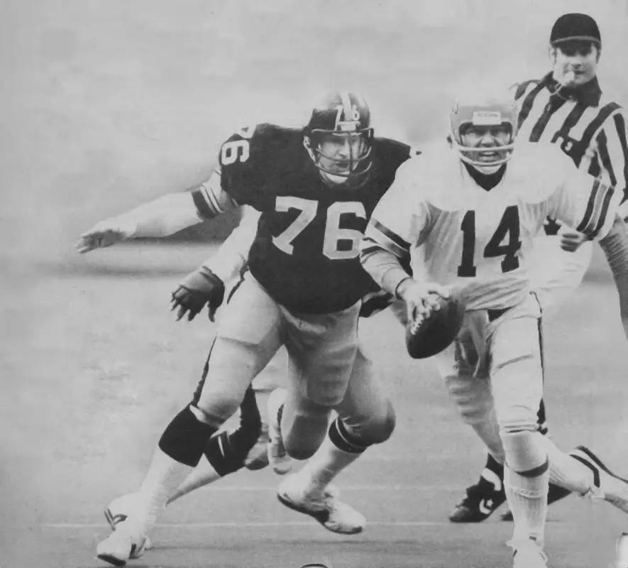 black and white photo of John Banazak forcing Nengals qb Ken Anderson to run.