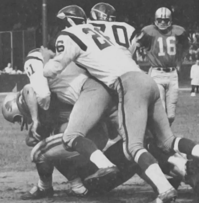 Black and white photo from 1965 of Washington Redskins defenders Sam Huff and Paul Krause a Detroit Lions runner.