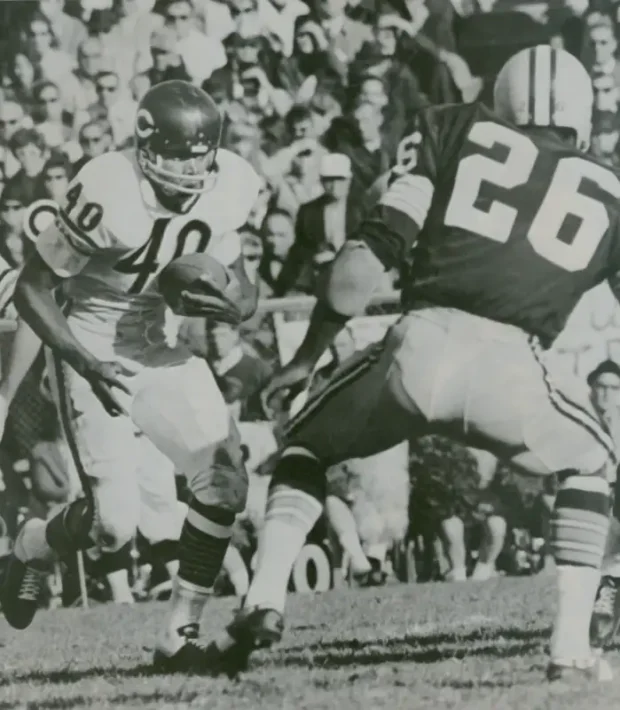 Gale Sayers faces Herb Adderley in a 1960s NFL action photo.