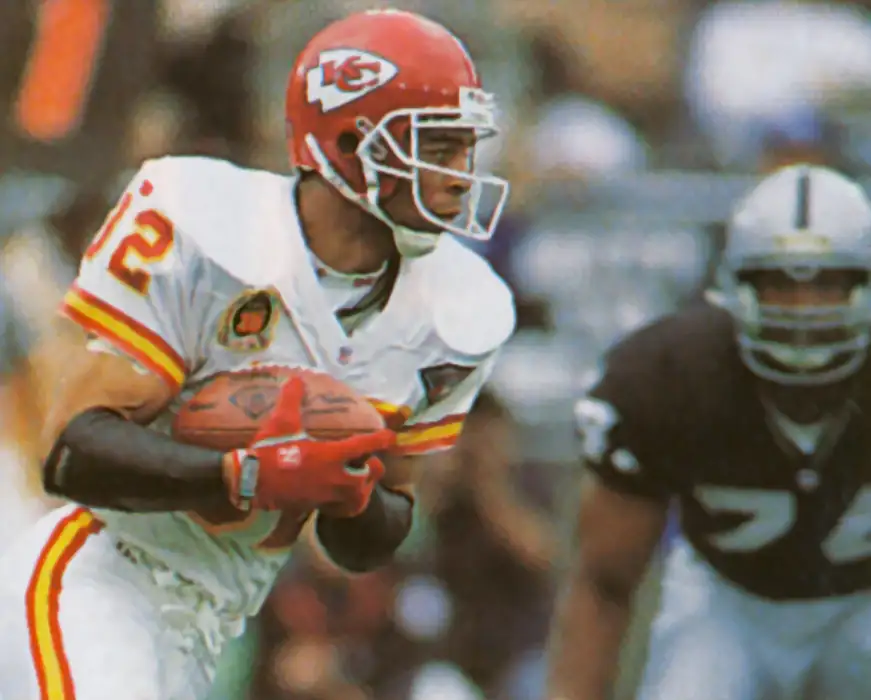 Picture of Marcus Allen in 1994 carrying the ball against the Raiders