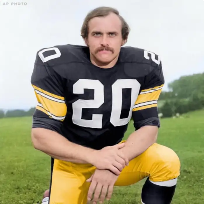 Picture of Steelers Rocky Bleier kneeling for a photgraph.