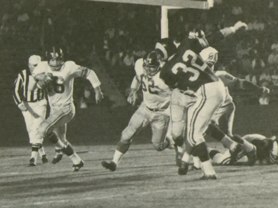 In 1962 Frank Gifford returned to the Giants after suffering a devastating injury 2 years before. He was switched to the Flanker position and ended up with 39 catches for 796 yards (a 20.6 YPC average) and 7 touchdowns. Here Giants lineman Darrell Dess gets out in front of him as Ram Jack Pardee moves up to engage.