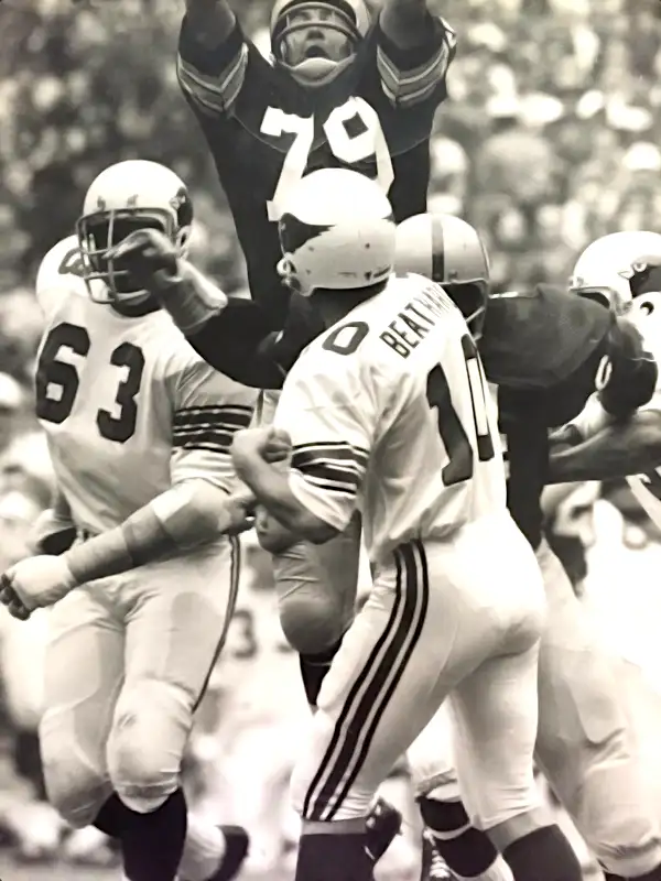 Ron McDole and friends apply a little bit of hindrance to the passing efforts of Cardinals quarterback Pete Beathard. Cardinal #63 is Clyde Williams of Southern.