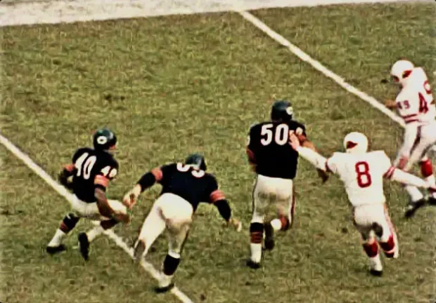 Gale Sayers carries against Larry Wilson and the Cardinals