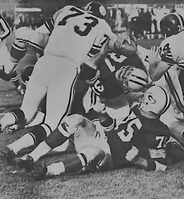 Behind Forrest Gregg, Jim Taylor can only manage a short gain this time against the Steelers defense. We think this is from the 1963 33-14 Packers win over Pittsburgh where Taylor rushed for 141 yards and a touchdown.