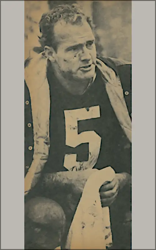 Paul Hornung sits on the Green Bay Packers sideline, towel in hand, streaked with mud and looking worn from a hard-fought game. Classic black-and-white NFL action capturing the legendary “Golden Boy” during the tough battles of the 1960s.
