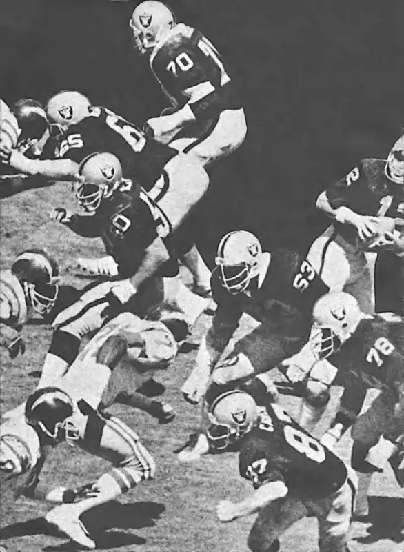 Nice picture of that great Raiders Offensive Line of the late 1970s as they form a pocket for QB Kenny Stabler against an on-coming Chargers rush. From top to bottom - Henry Lawrence (#70), Mickey Marvin (#65), Dave Dalby (#50) and Hall of Famers Gene Upshaw (#63) & Art Shell (#78). Tight End Dave Casper (#87) & Kenny Stabler (#12) are also seen.