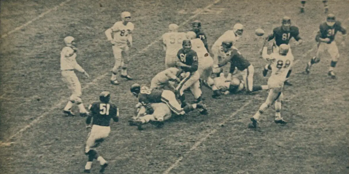 Tobin Rote connects with End Steve Junker in a 1957 showdown with Chicago. When Bobby Layne went down with a broken ankle, Rote took over a guided the Lions through the next 3 games including a playoff win over the 49ers and a title victory over the Browns.
Lions players here Rote at quarterback, Steve Junker catching the pass, center Frank Gatski, #52 and #87 Dorne Dibble of Michigan State.
And for the Bears, some great here #81, Doug Atkins #61 Bill George #52, Wayne Hansen #82, Jack Hoffman and #31, Joe Fortunato.