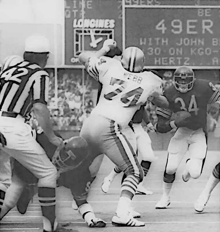 This image captures Walter Payton scoring a touchdown against the San Francisco 49ers in Week 2 of the 1976 season. Payton rushed for 148 yards in the game and finished the year second in the NFL with 311 carries for 1,390 yards and 13 touchdowns, averaging 4.6 yards per carry. This play shows his second touchdown of the day—a 7-yard scoring run.