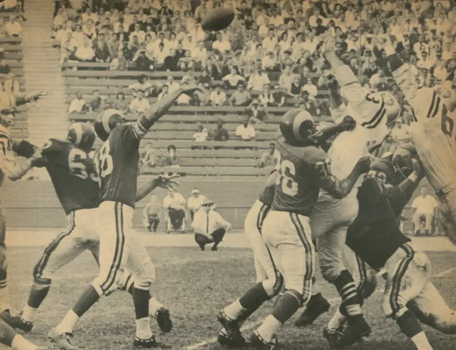Second-Year Man Roman Gabriel looks like he's going deep as the San Francisco 49er pass rush is held back back Ram blockers. #36 in the foreground looks like fullback Ben Wilson.