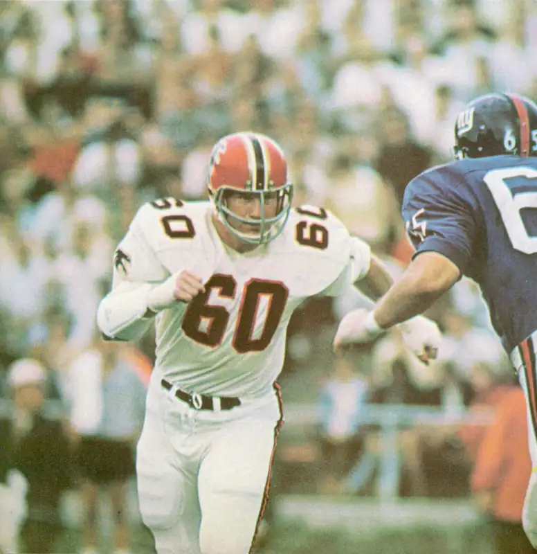 Tommy Nobis moves in during an early Atlanta Falcons game. Chosen first overall in the 1966 NFL Draft, Nobis became the first player in franchise history and spent 11 seasons with Atlanta, earning five Pro Bowl selections while establishing himself as the club's defensive leader of those early Falcon squads. The Giant here looks like Guard Pete Case.