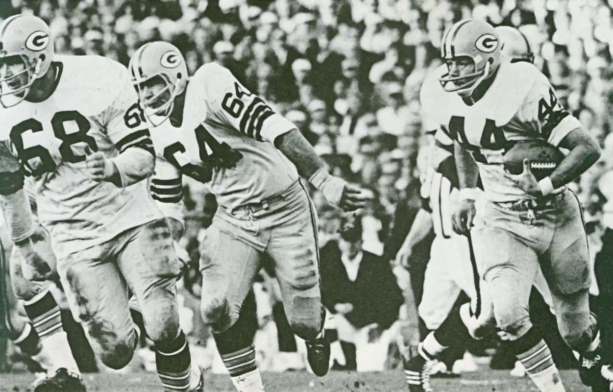 Green Bay Packer offense in the mid-1960s. Offensive lineman Jerry Kramer and Gale Gillingham lead the way for running back Donny Anderson.